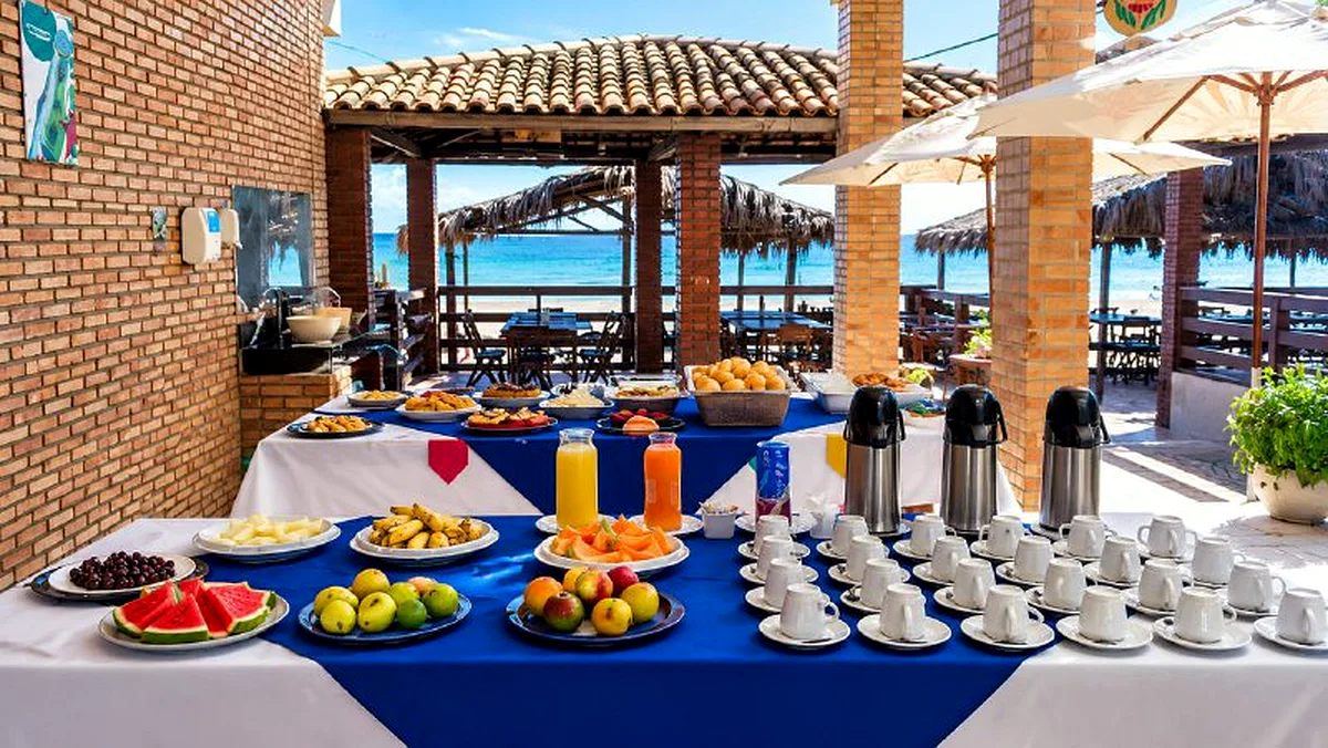 Mesa de frutas, sucos e café de frente para o mar