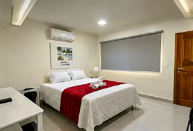 Suíte Conforto com cama de casal, ar-condicionado e quadro na parede