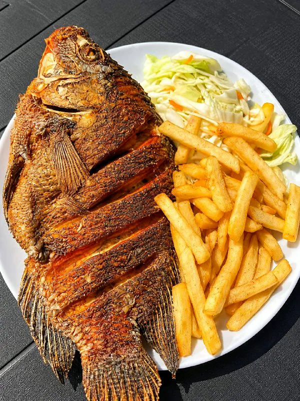 Peixe frito inteiro com batata frita e salada