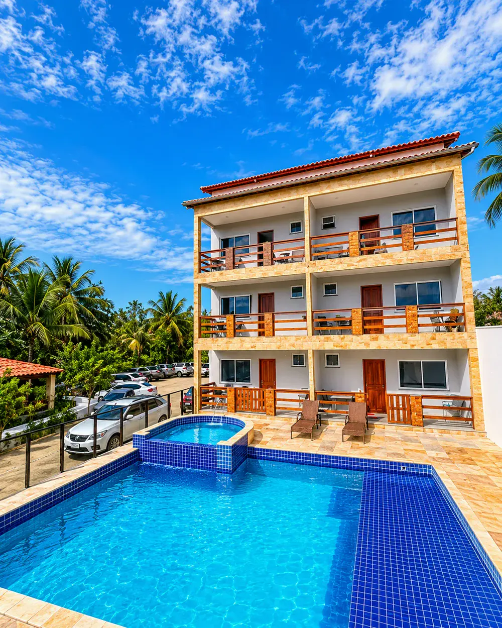 Prédio de três andares com varandas de madeira de frente para a piscina